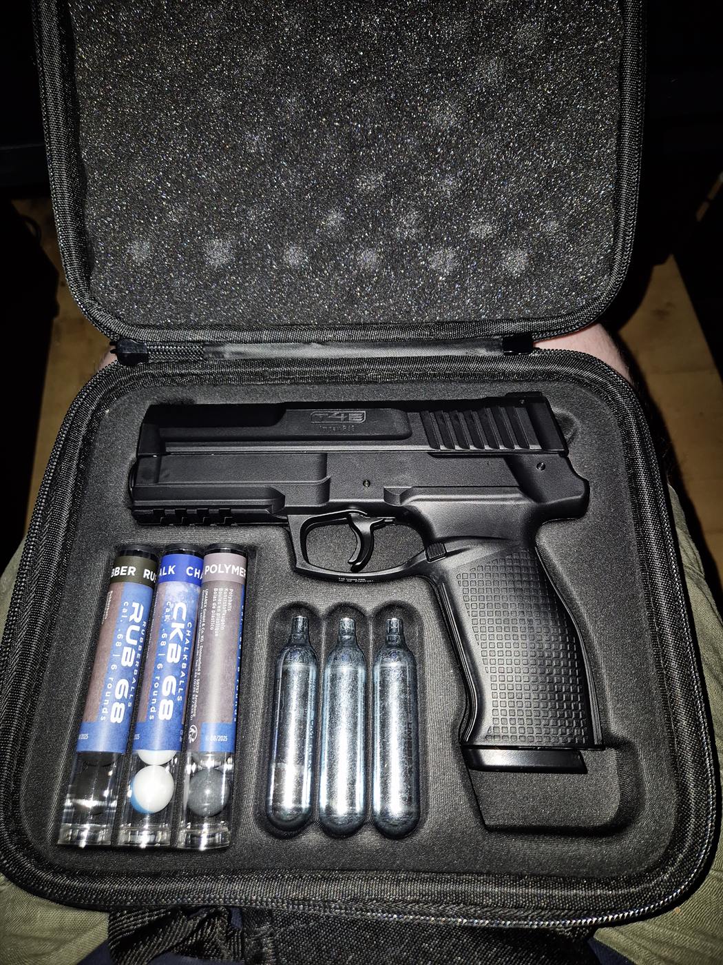 Mallette Impax P68 ouverte vue du dessus : pistolet, tubes RUB68, CKB68 et POLYMER, trois cartouches CO2 de 12 g dans la mousse